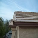 Looking up at a bird wire and post system run along the front roof tiles